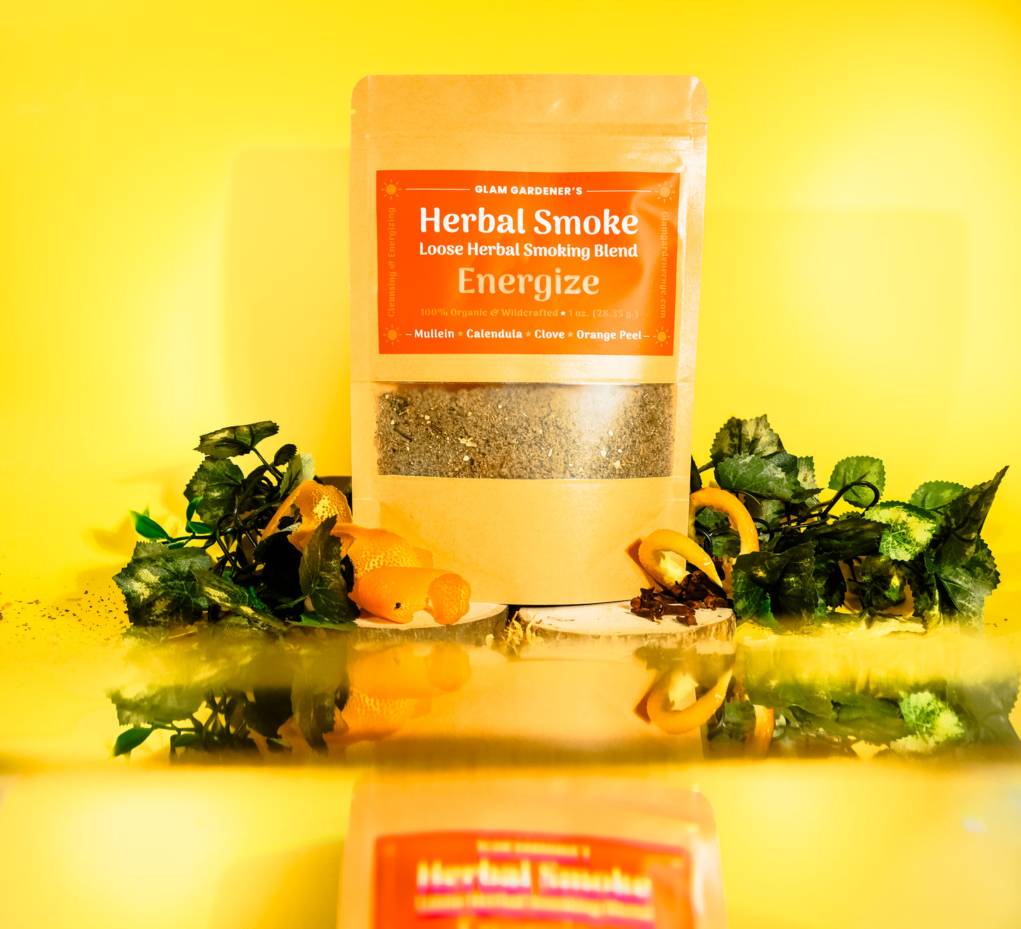 Glam Gardener NYC‘s loose herbal smoking blend called energize. It features mullein, calendula, clove, and orange peel. It’s 100% wildcrafted and organic. The background is yellow and there are orange spirals as a decorative element in the photoshoot.