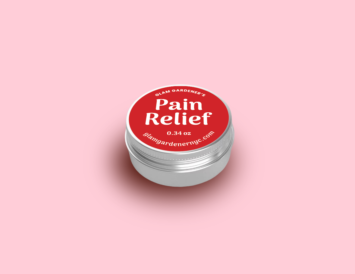 Glam Gardener's mini healing salve. Pain Relief with Arnica, Comfrey, and Peppermint. This mini salve is .34 ounces and a mini version of our standard size salve. The in is red, mall, and aluminum, and the background of the image is a light red.