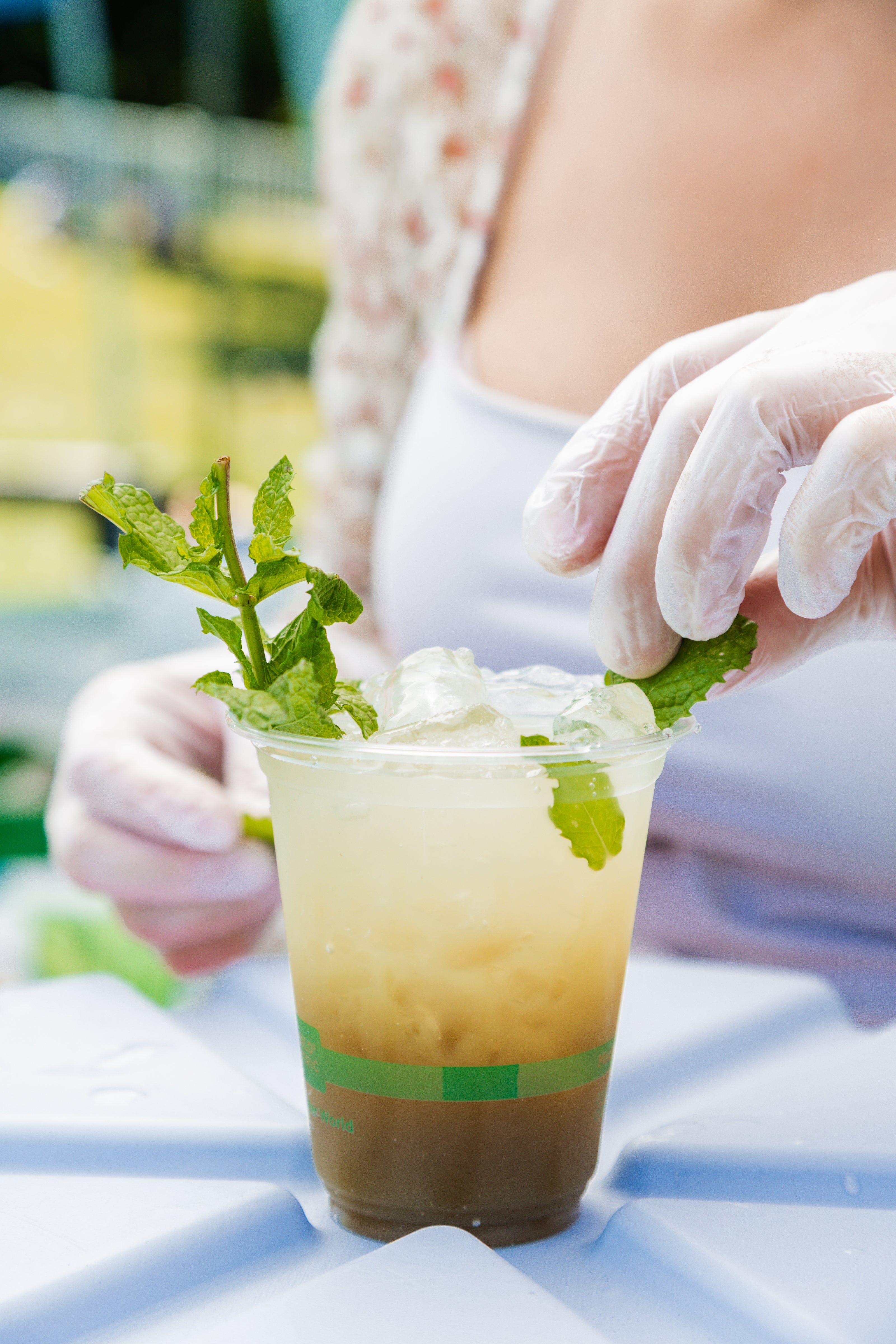 Glam Gardeners Herbal Mocktail Service in NYC! This is the Matcha Mint Mojito, a signature beverage of Glam Gardener's Botanical Bar. This image shows the bartender, the Glam Gardener making the minty drink.