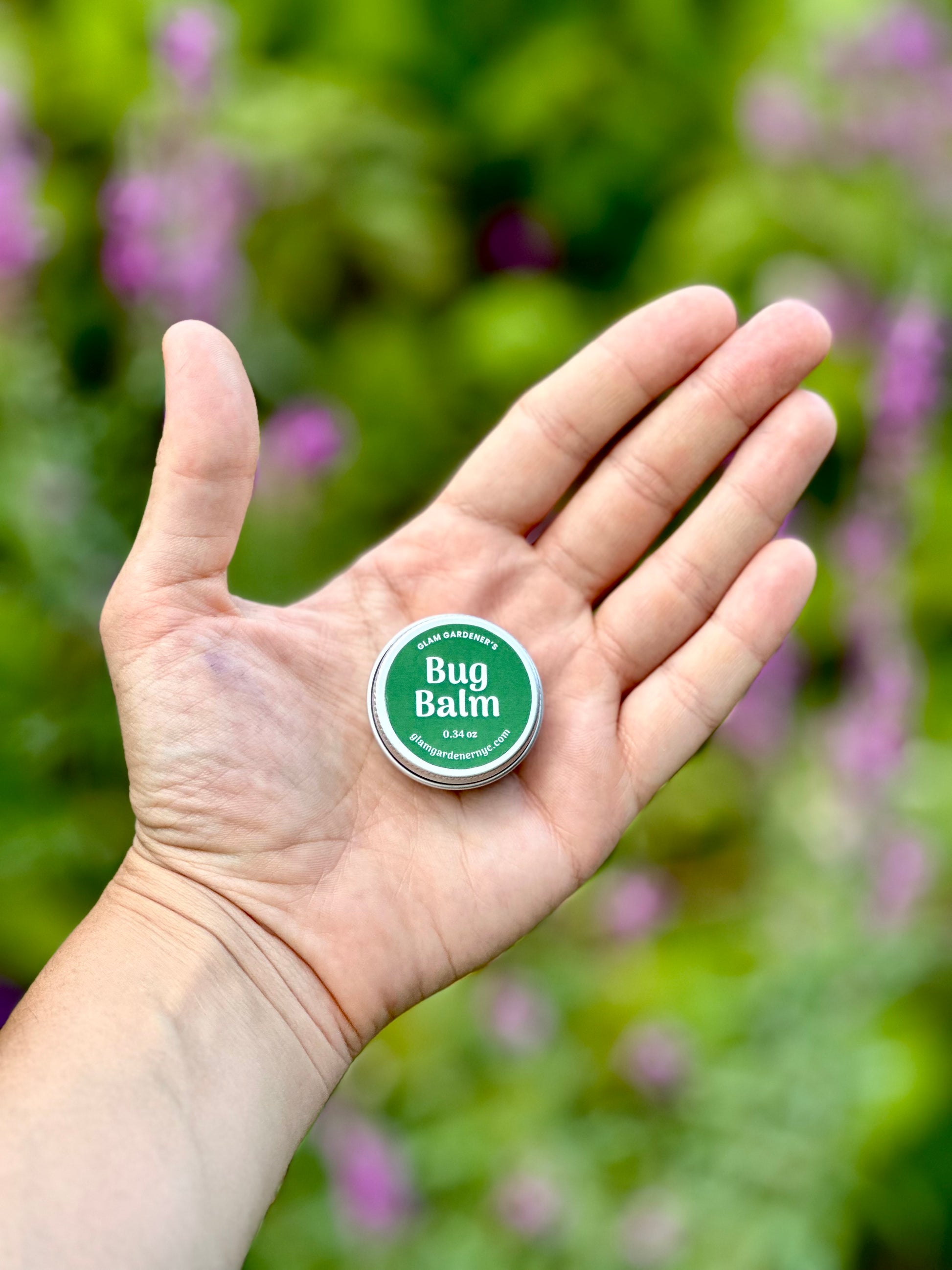 Hand holding small miniature bug repellent salve by Glam Gardener NYC