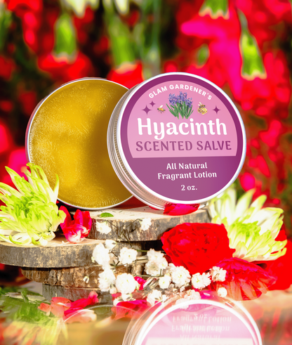 Hyacinth Blooms Scented Salve is Glam Gardener's Signature salve infused with authentic Hyacinth Absolute Oil. The label is a dual toned pink color and the backrgound showcases flowers. The salve contains a creamy solid perfume and hydrating lotion made with Olive Oil, absolute oil, and beeswax.
