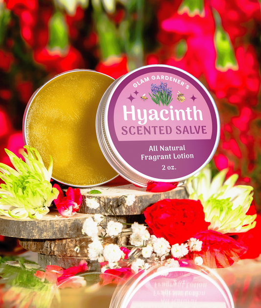 Hyacinth Blooms Scented Salve is Glam Gardener's Signature salve infused with authentic Hyacinth Absolute Oil. The label is a dual toned pink color and the backrgound showcases flowers. The salve contains a creamy solid perfume and hydrating lotion made with Olive Oil, absolute oil, and beeswax.