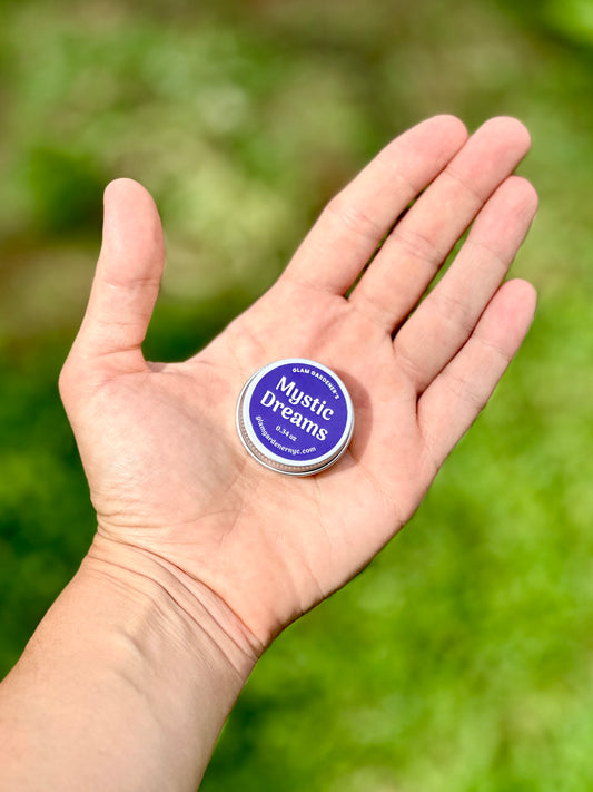 Hand holding Glam Gardener's Mystic Dreams Mini Salve with Mugwort & Lavender for you to see the real size.