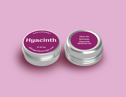 Glam Gardener NYC mini Hyacinth Blooms salve contains Olive Oil, beeswax, and hyacinth absolute oil. It is 0.34 ounces and is available at glamgardenernyc.com. It is all natural and has a pink label.