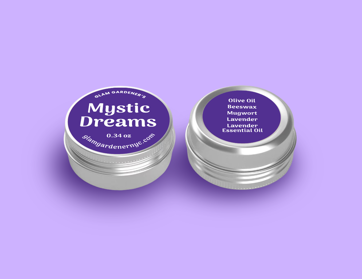 Glam Gardener's mini mystic dreams salve is a mini version of our standard sized salve with lavender, mugwort, olive oil, lavender essential oil, and beeswax. It smells like lavender. The image shows the salve enlarged for readability with a purple label and a purple background. The salve is available at glamgardenernyc.com